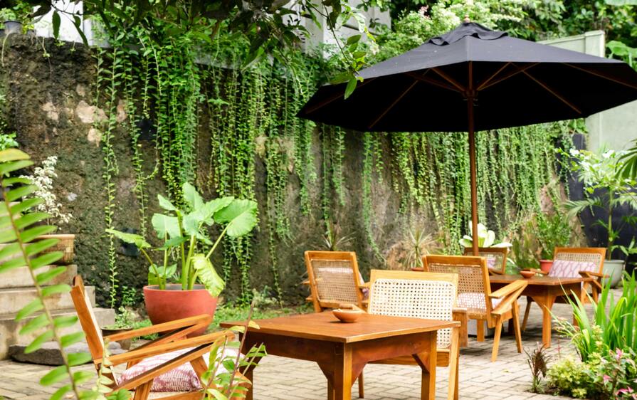 Terrasse mit Gartenmöbeln, Schirm und Pflanzen